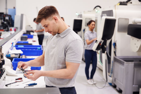 Male Engineer Quality Controlling Components In Factory